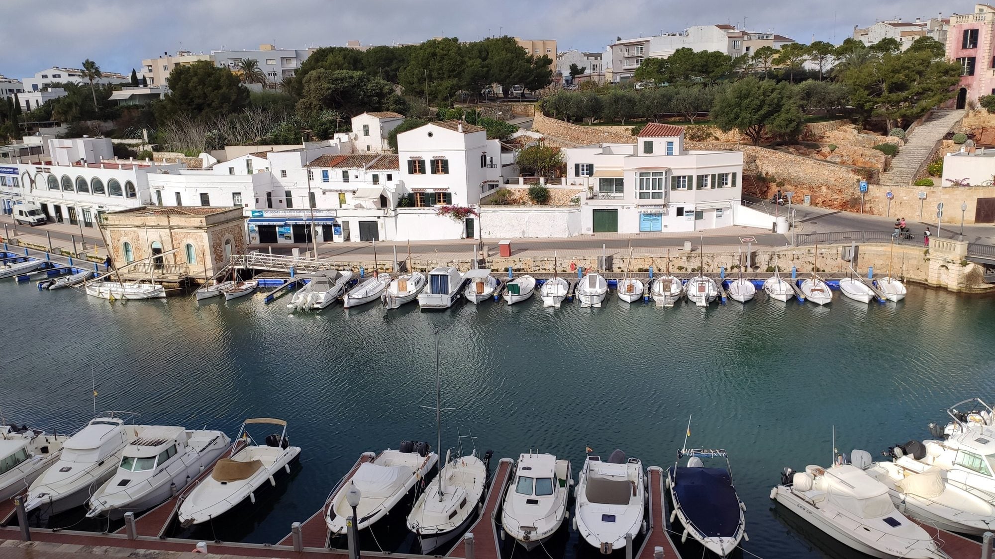 Puerto de Ciutadella al atardecer, con barcos amarrados junto a las casas